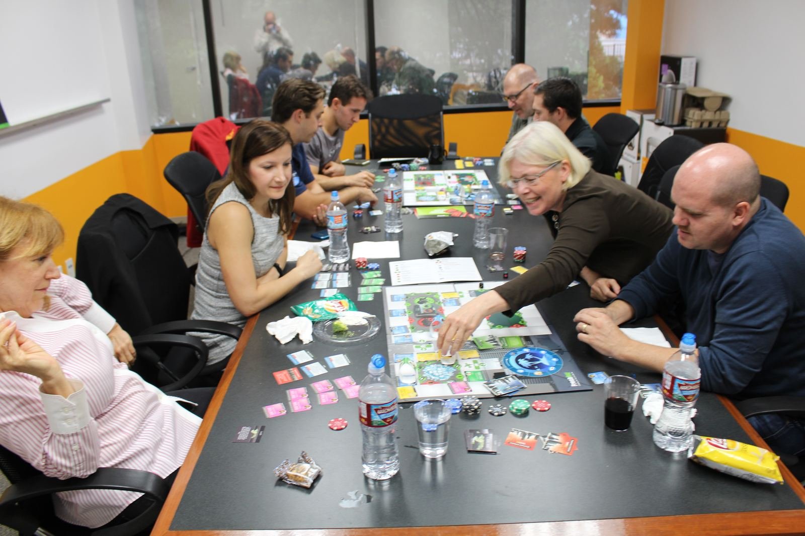 Team gathered around a game board during a facilitated session